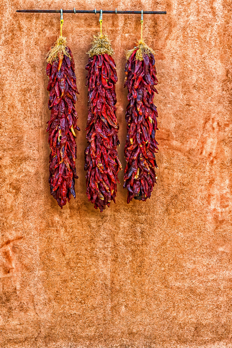 Three Ristras on Adobe