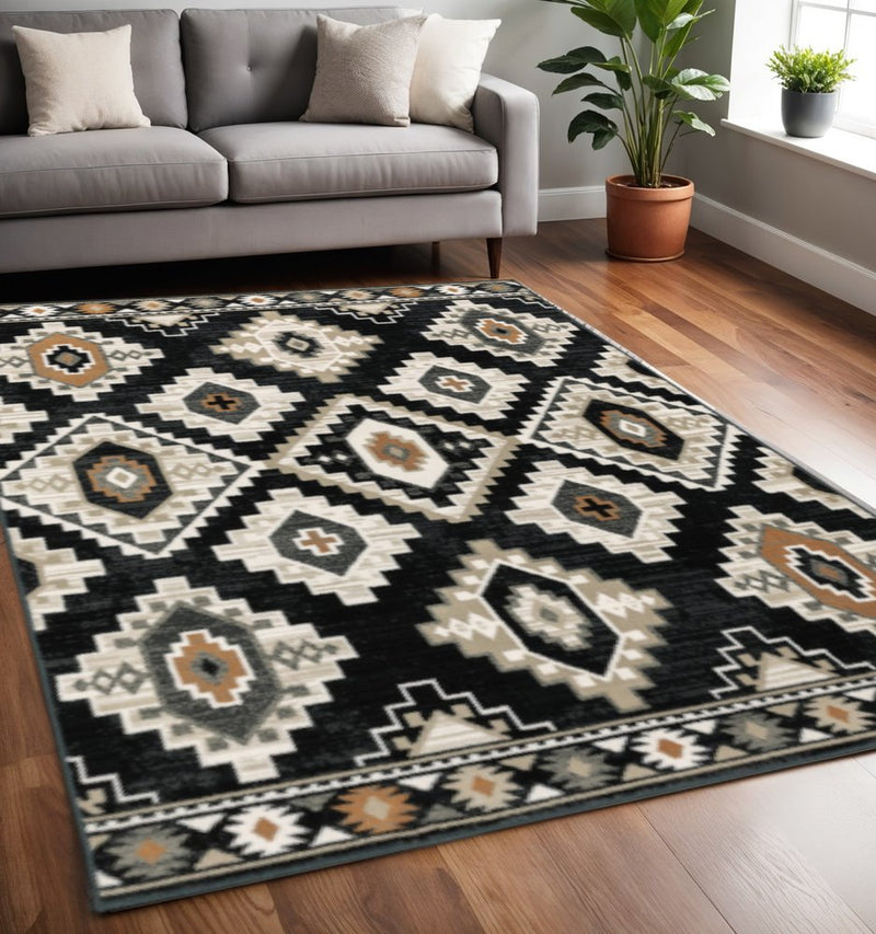 5' X 7' Black Grey Tan Orange And Ivory Southwestern Power Loom Stain Resistant Area Rug
