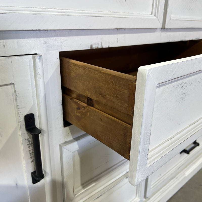 White wooden cabinet with a drawer open, revealing a wooden interior.