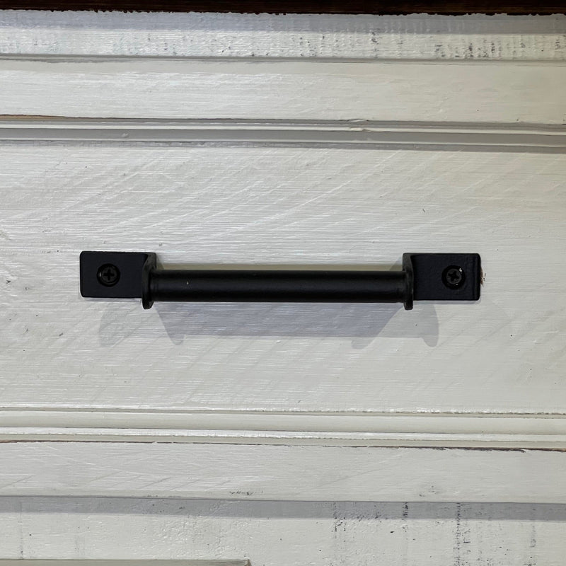 Black metal handle on a textured white surface